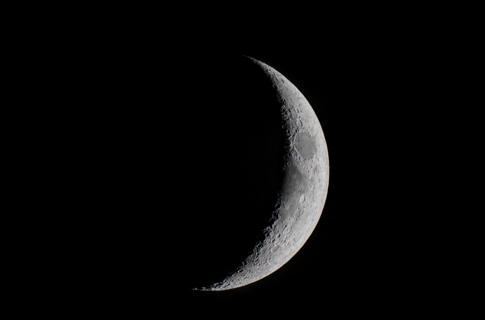 Un gros plan d'un croissant dans le ciel sombre avec un petit nuage (lune, pleine lune, phase lunaire, croissant, vénus)