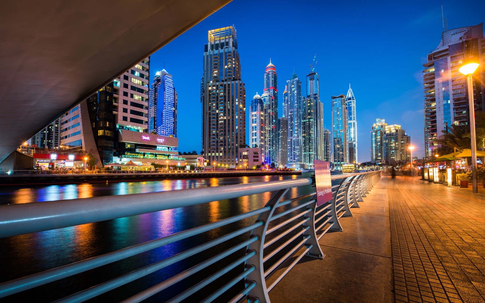 Vista do horizonte de uma cidade à noite com uma ponte e um rio (marina de dubai, paisagem urbana, área urbana, cidade, metrópole)