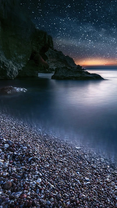 Sternen Nacht über einem ruhigen schwarzen Kiesstrand