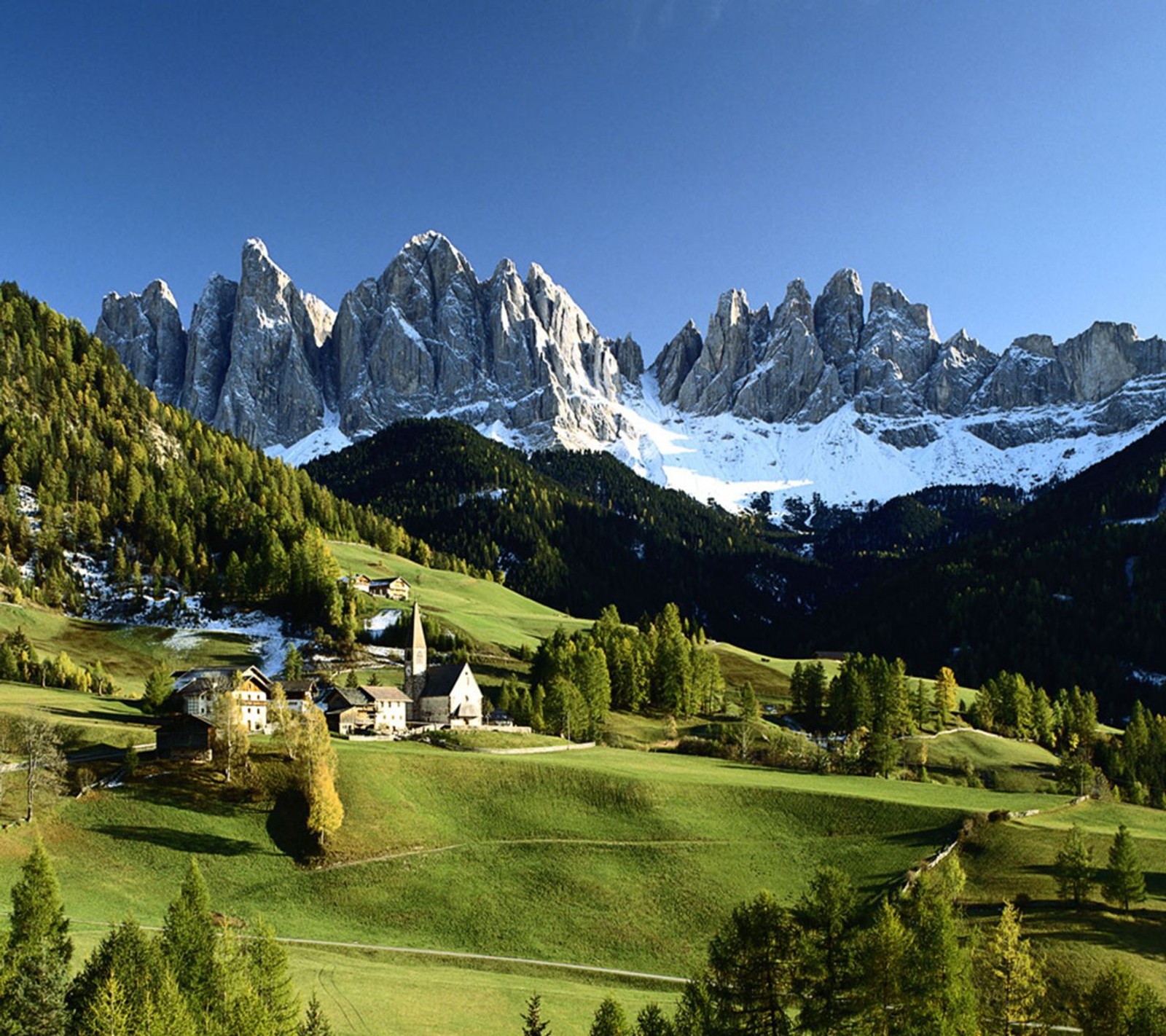 Des montagnes enneigées avec un petit village au premier plan (nuages, paysage, montagne, naturel, nature)