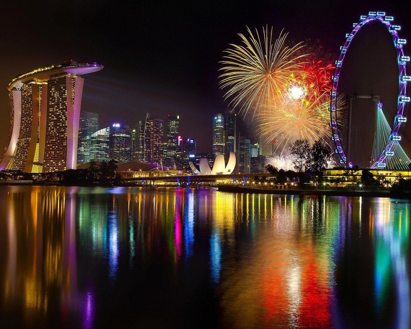 Les feux d'artifice illuminent la ligne d'horizon de singapour vue depuis l'eau (bâtiments, coloré, lac, nuit, mer)