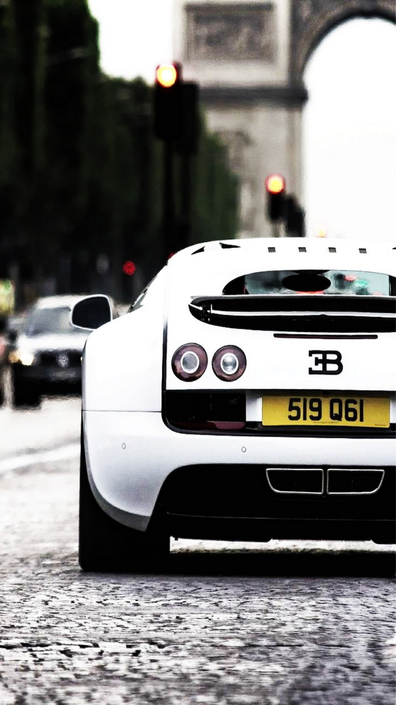 Une voiture de sport blanche roulant dans une rue devant un grand arc (3b, voiture, supersport, blanc)