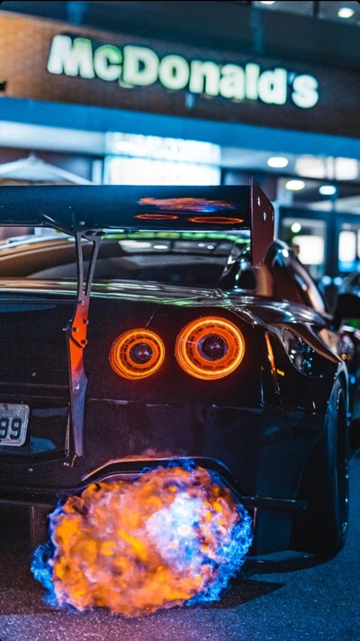 Éblouissant Nissan GTR R35 avec moteur RB26, montrant des flammes sur fond de McDonald's