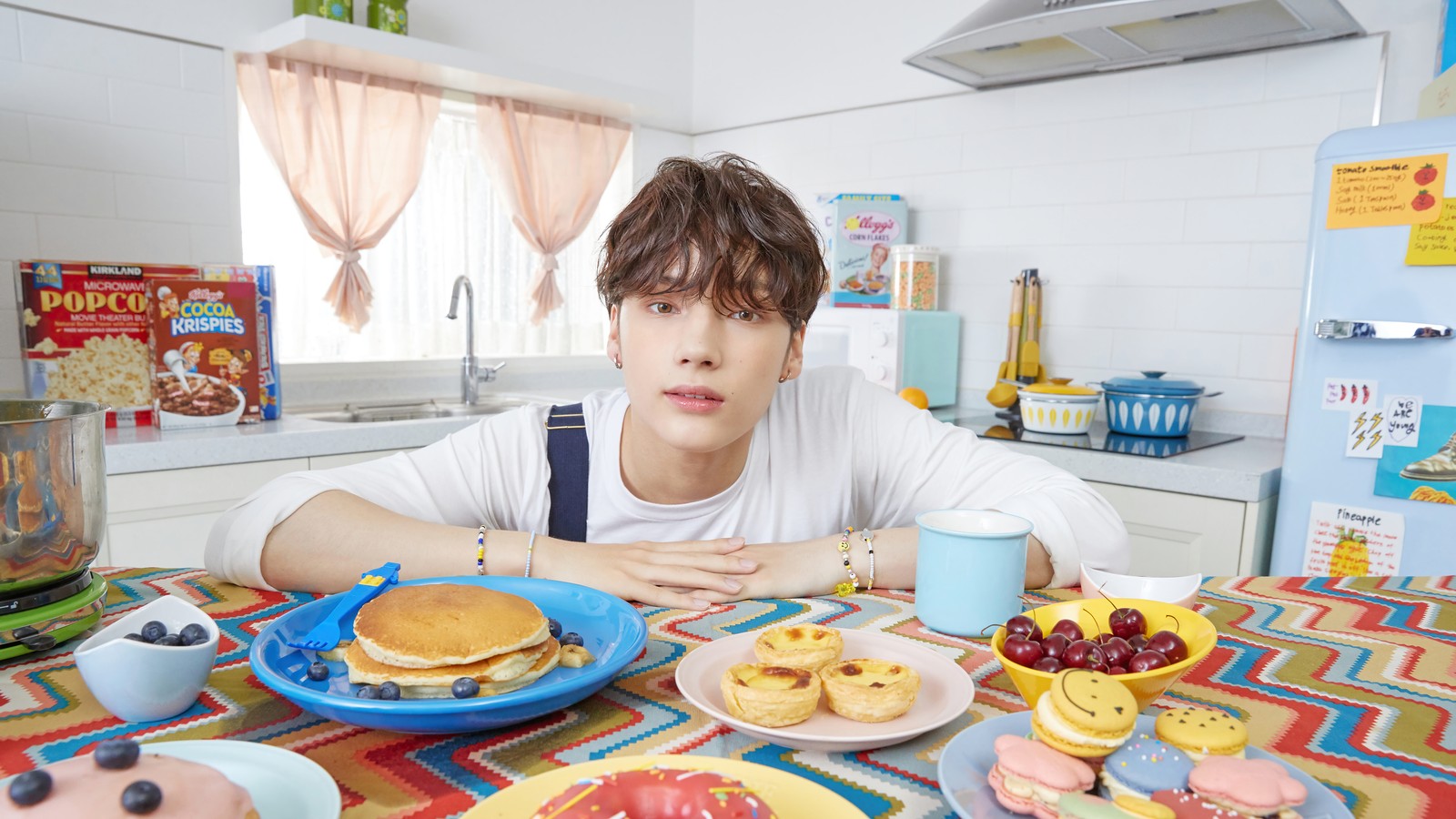 Hay un hombre sentado a una mesa con un plato de comida (txt kpop, tomorrow x together, 투모로우바이투게더, kpop, k pop)