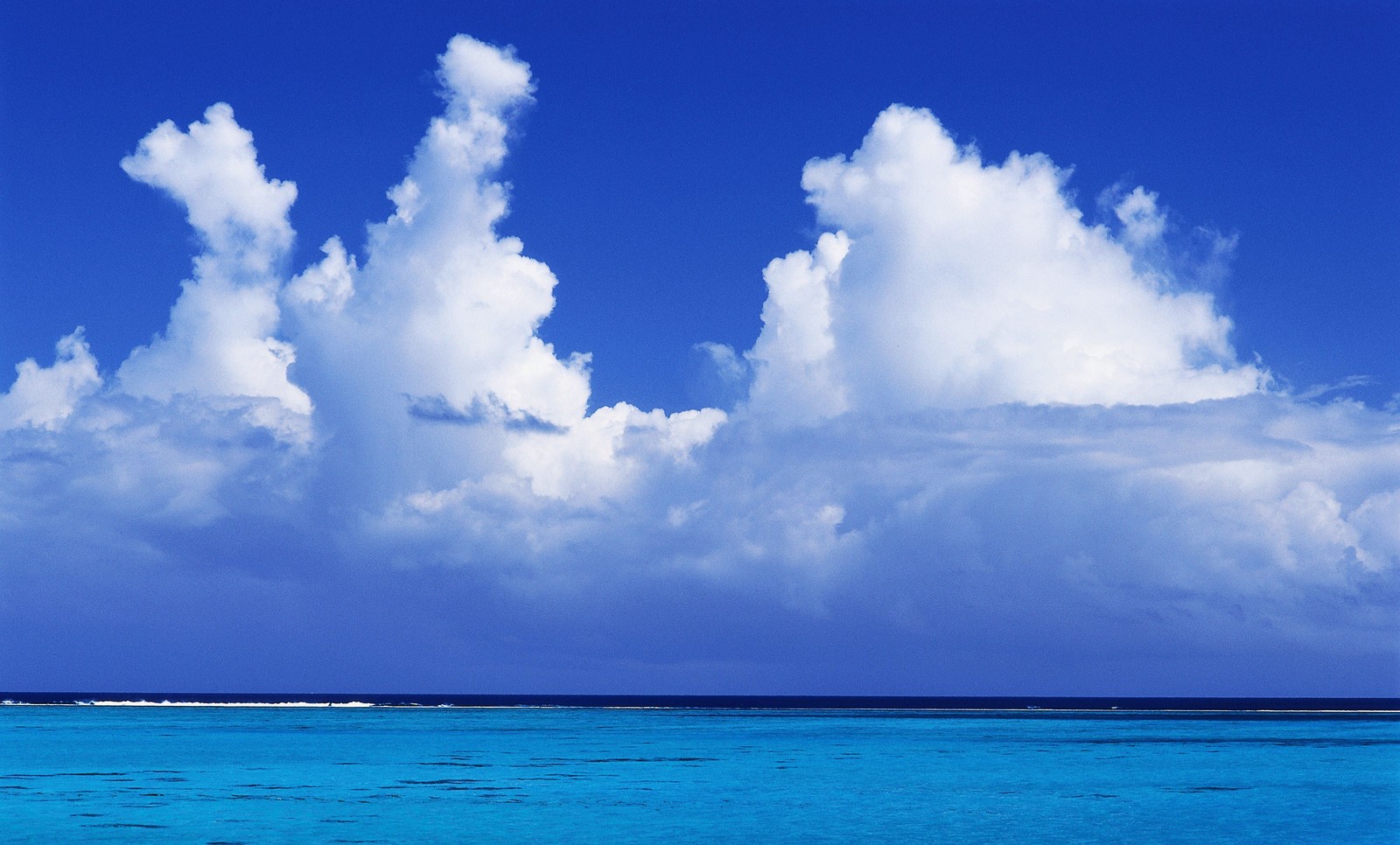 Des nuages dans le ciel au-dessus de l'océan et un bateau dans l'eau (nuage, bleu, journée, cumulus, mer)