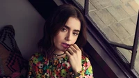 Lily Collins dans une tenue florale vibrante, capturée dans un moment candide lors d'une séance photo.