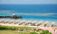 Resort de playa tranquilo con tumbonas y un muelle pintoresco con vistas al océano