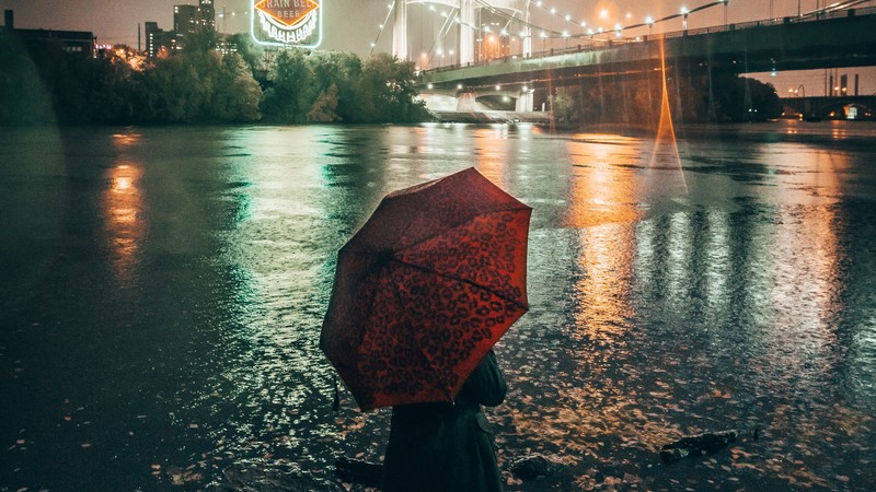 Арфед человек с зонтом, стоящий под дождем рядом с мостом (вода, красный, отражение, вечер, городская территория)