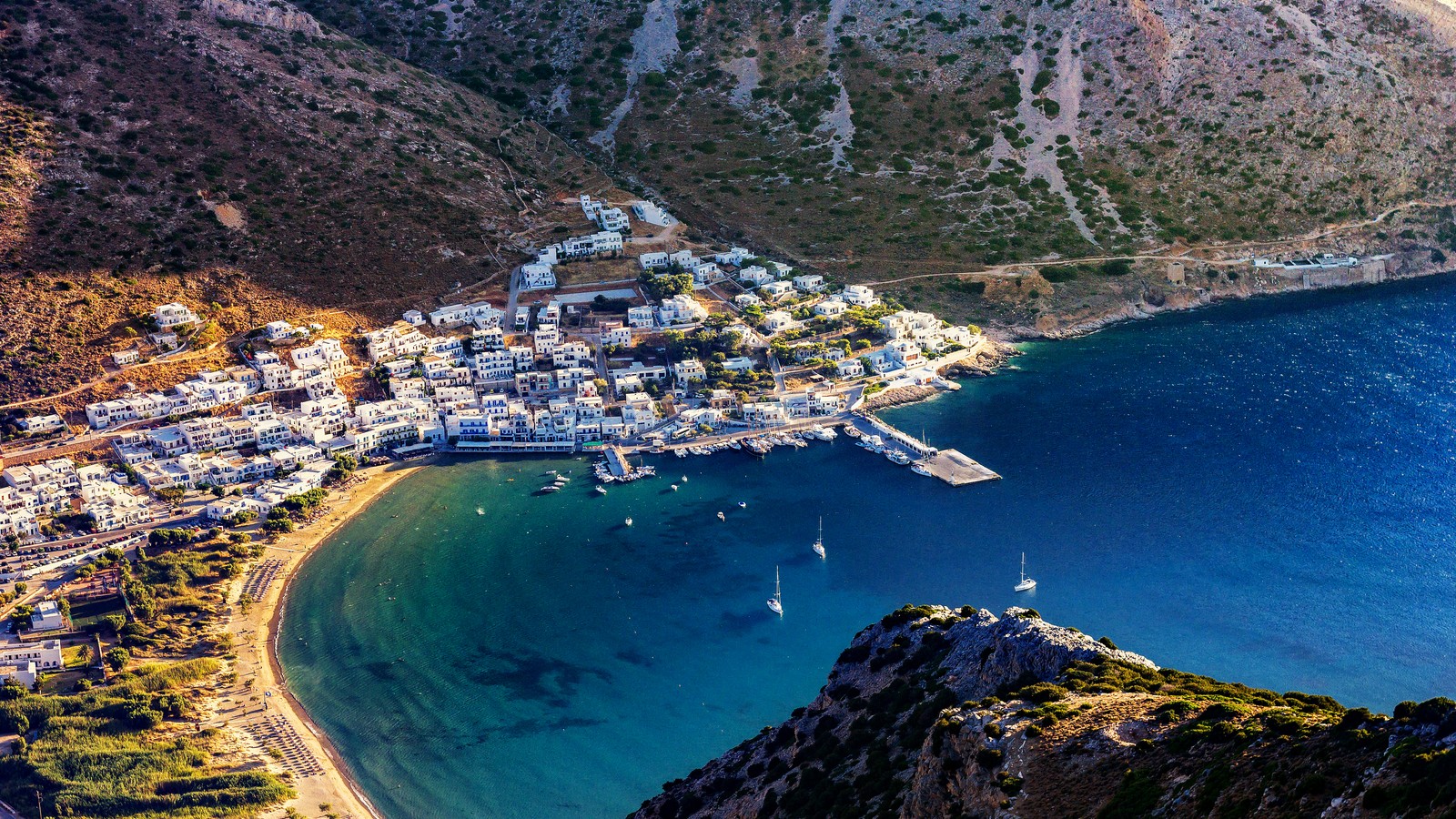 Vista de uma pequena cidade na costa de uma baía (sifnos, grécia, ilha, atração turística, visão aérea)