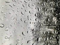 Primer plano en blanco y negro de gotas de lluvia en una ventana