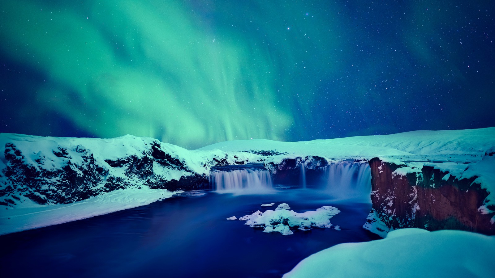 A large waterfall with a green aurora light above it (snow covered, godafoss waterfall, winter, iceland, aurora sky)