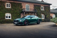 Elegante Bentley Continental GT em frente a uma mansão clássica de tijolos