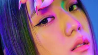 Jisoo from BLACKPINK with vibrant lighting and striking makeup.