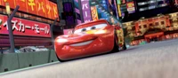 Rayo McQueen corriendo a través de un vibrante paisaje urbano