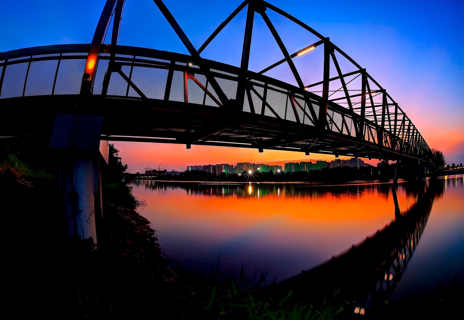 Luftaufnahme einer brücke über einen fluss mit einem gebäude im hintergrund (reflexion, brücke, wasser, nacht, bogenbrücke)