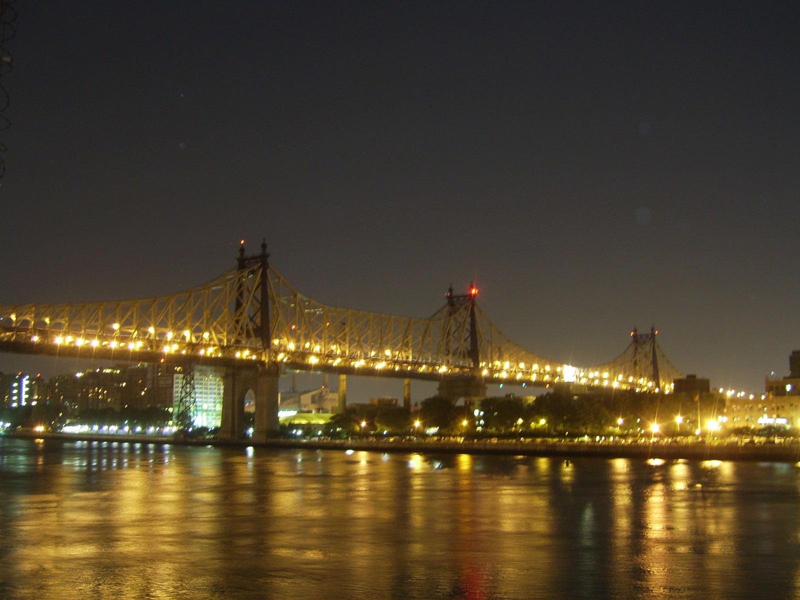 Arafed ponte sobre um rio à noite com luzes refletindo na água (ponte, atração turística, noite, marco, cidade)