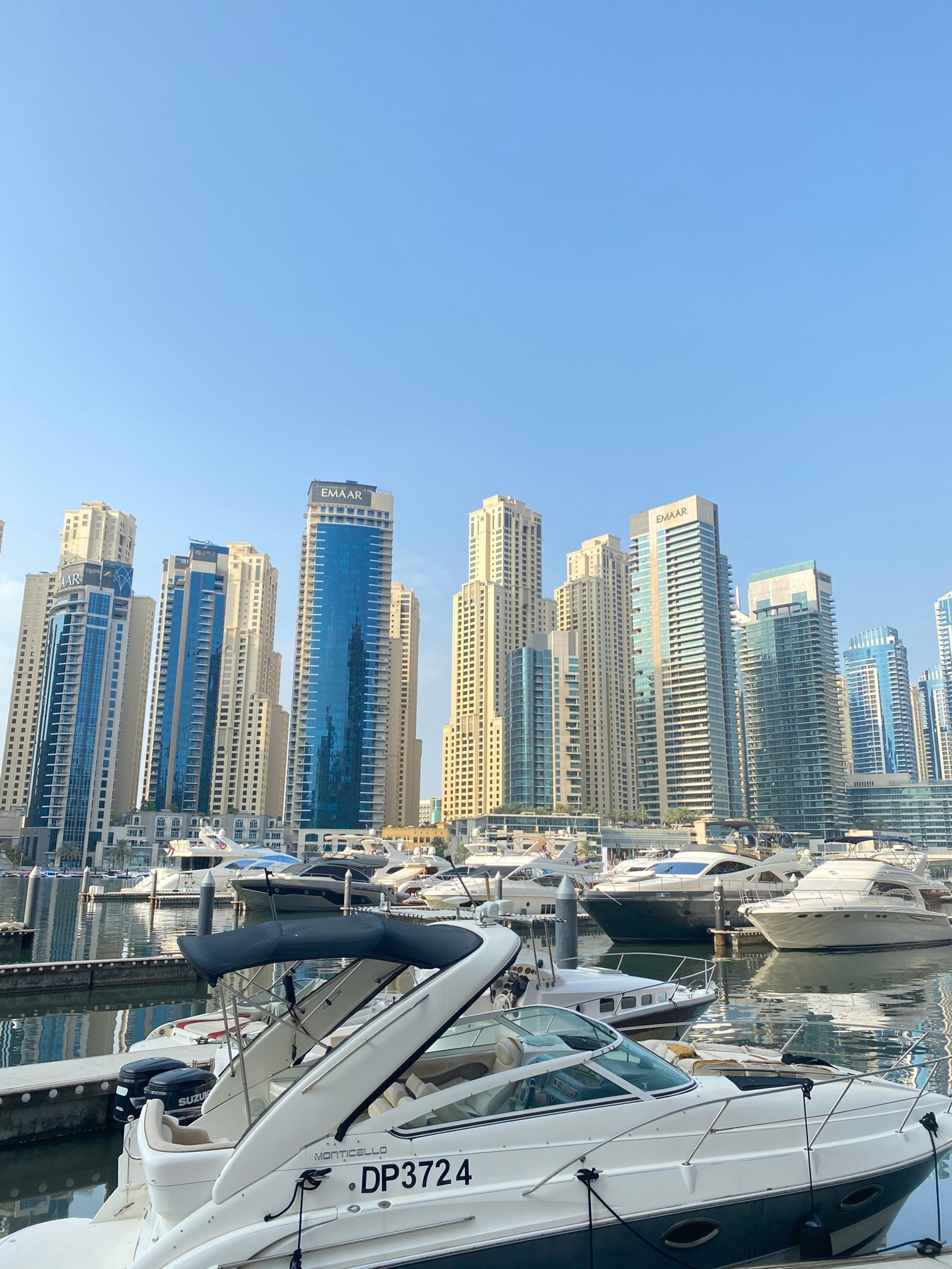 Barcos atracados em uma marina com uma cidade ao fundo (dubai, marina, água, bloco de torre, embarcação)