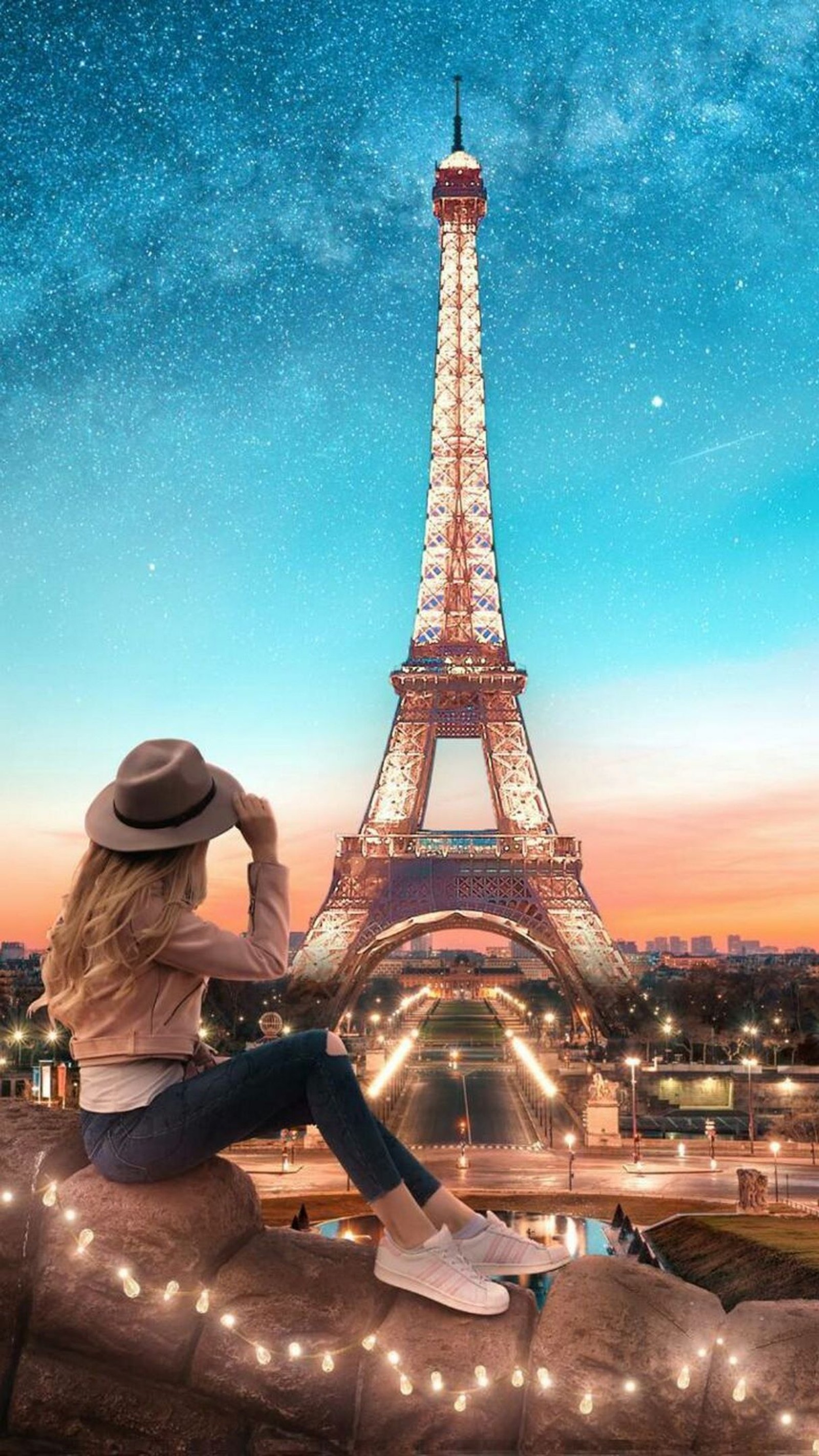 Une femme assise sur une pierre regardant la tour eiffel (bleu, sombre, nuit, paris, côté)