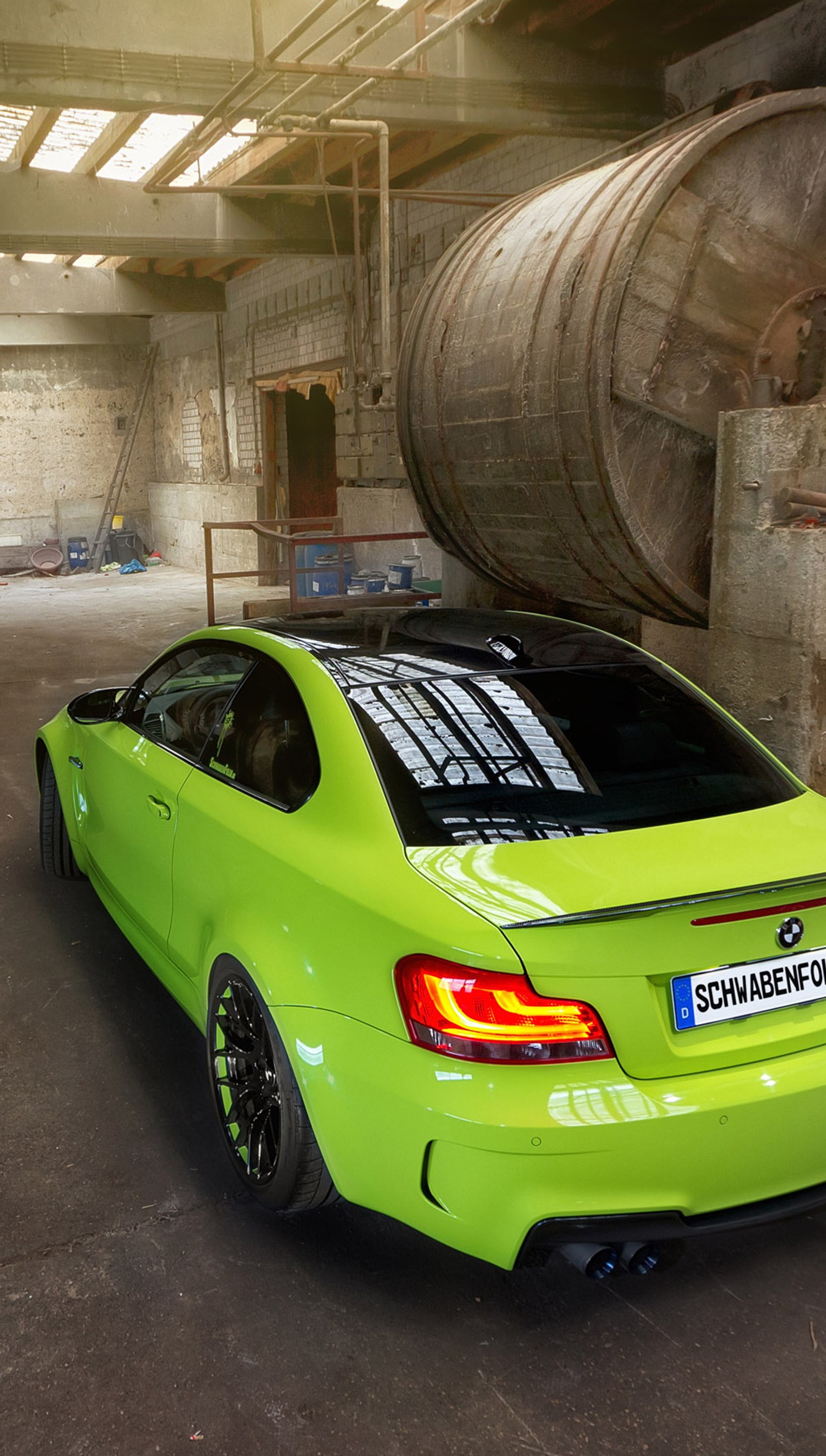 Arafed green bmw car parked in a large warehouse with a barrel of wine in the background (auto, best, car, green)