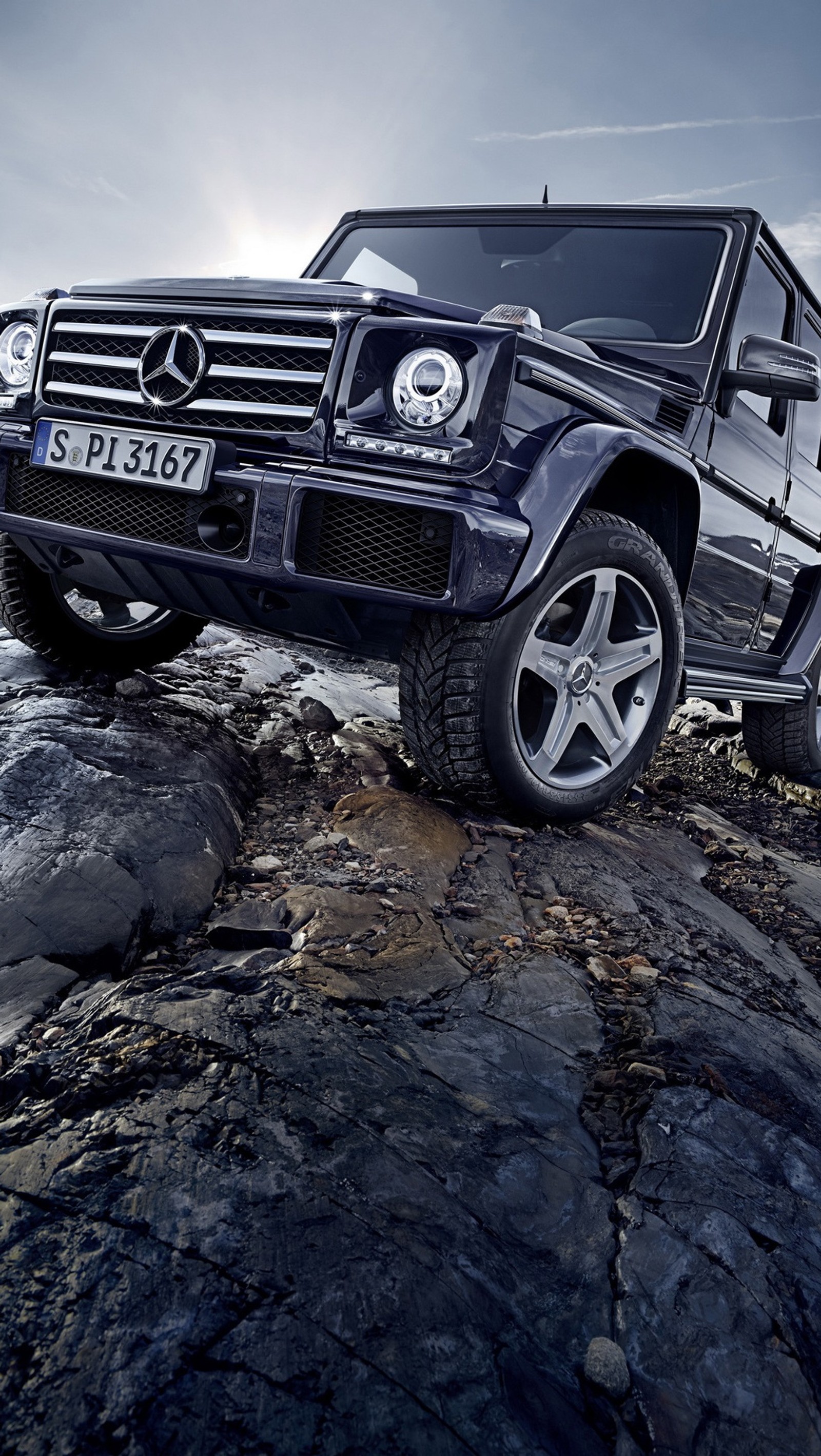 Arafed vehicle parked on a rocky beach with a cloudy sky (benz, g500)