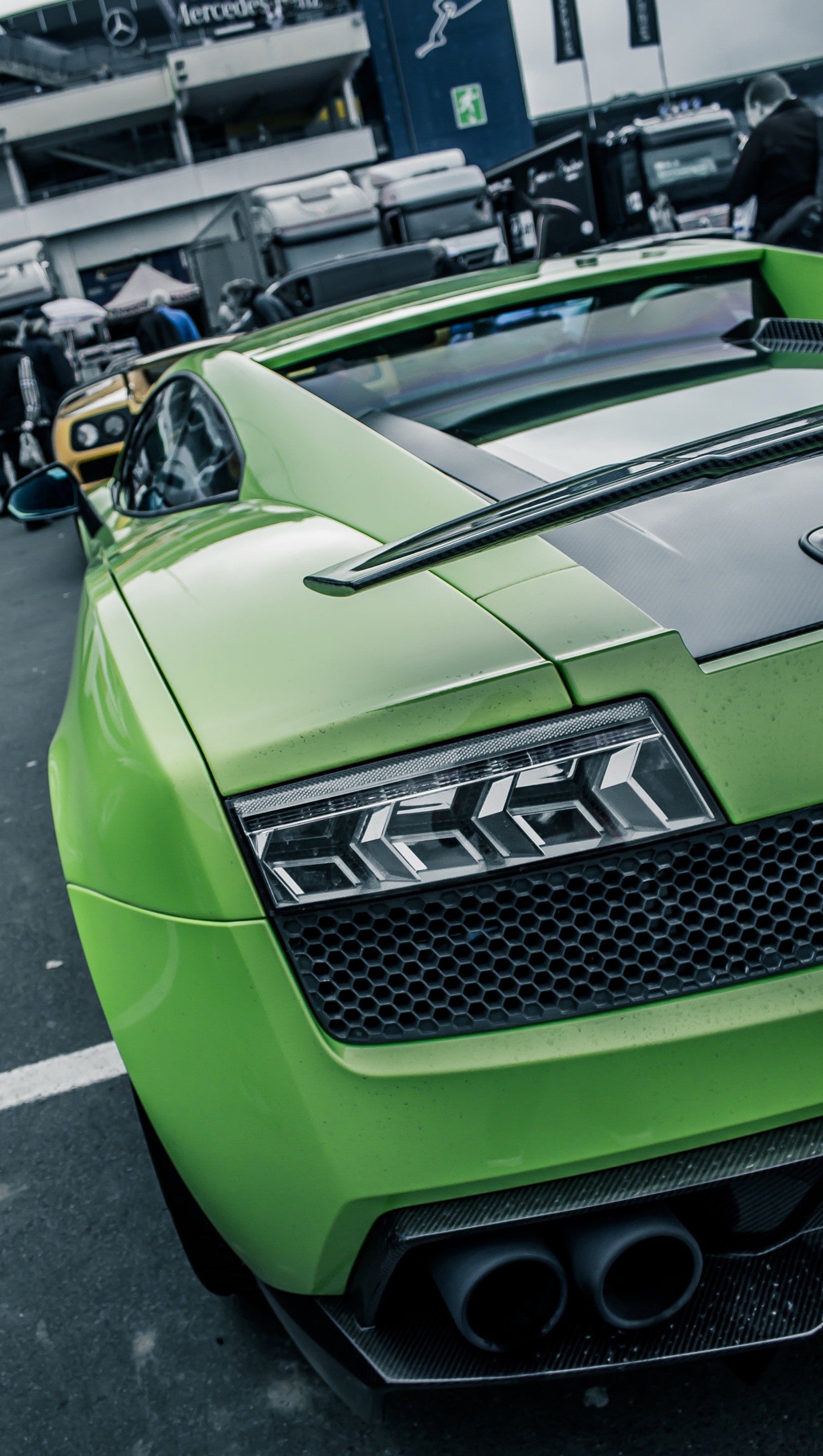 A close up of a green sports car parked in a parking lot (aventador, car, green, lamborghini)