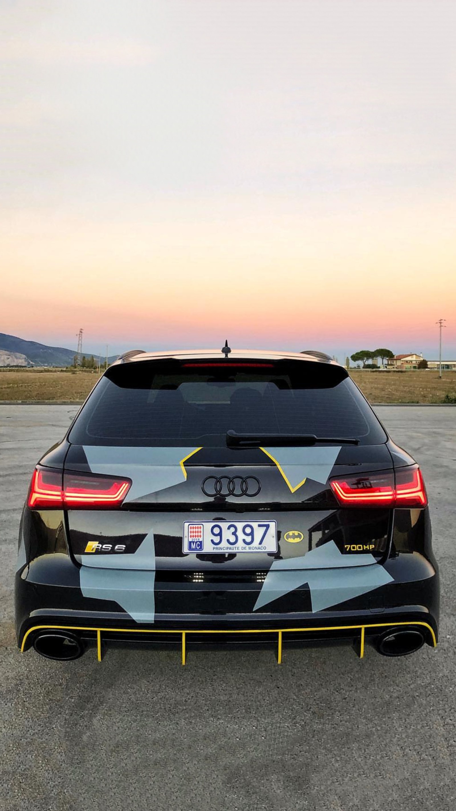 Nahaufnahme eines autos, das auf einem parkplatz mit sonnenuntergang im hintergrund parkt (audi, rs6, schwarz, gelb, rs)