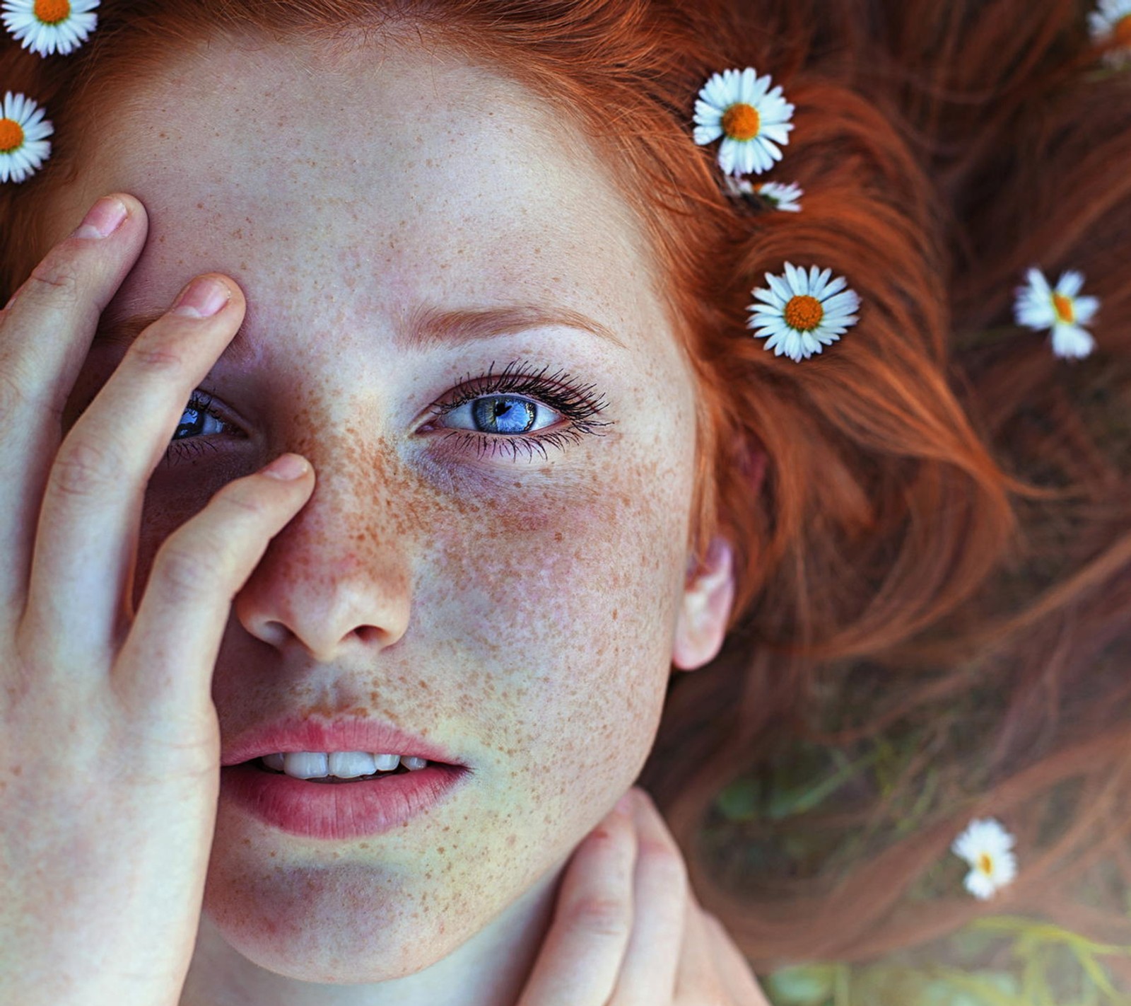 Il y a une femme avec des taches de rousseur sur la tête allongée (beauté, printemps)