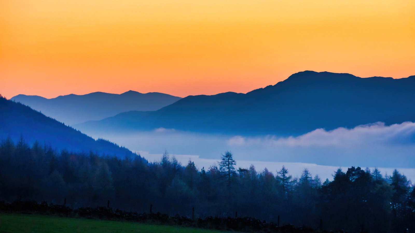 A view of a mountain range with a valley in the distance (forest, mountain, mountains, fog, nature)