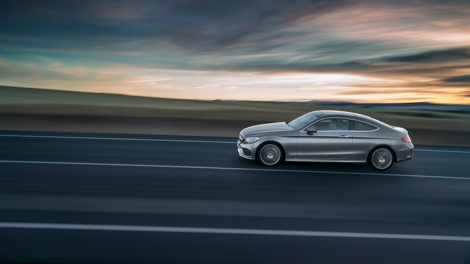 El mercedes c-class coupe conduciendo por una carretera al atardecer (coche, daimler ag, golpe, coche de lujo, coche de alto rendimiento)