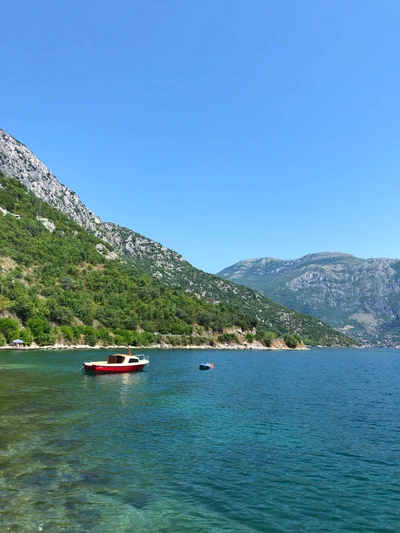 Ruhige Wasserlandschaft mit Booten und bergiger Landschaft