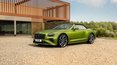 2024 Bentley Continental GT Speed Convertible en Verde Vibrante, Frente a un Fondo Arquitectónico Moderno