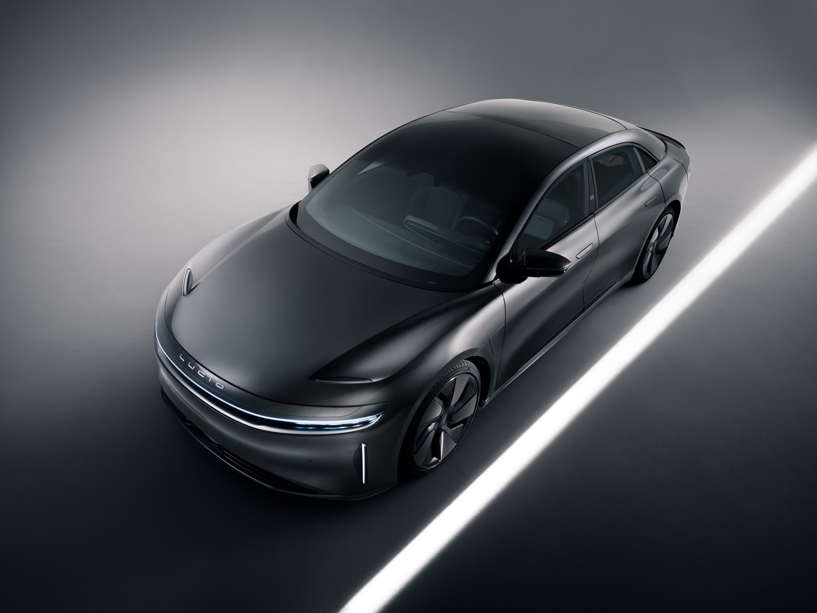 Крупный план автомобиля, движущегося по дороге с освещением (lucid air grand touring stealth, 2023, 5k, машины, обои 4k)