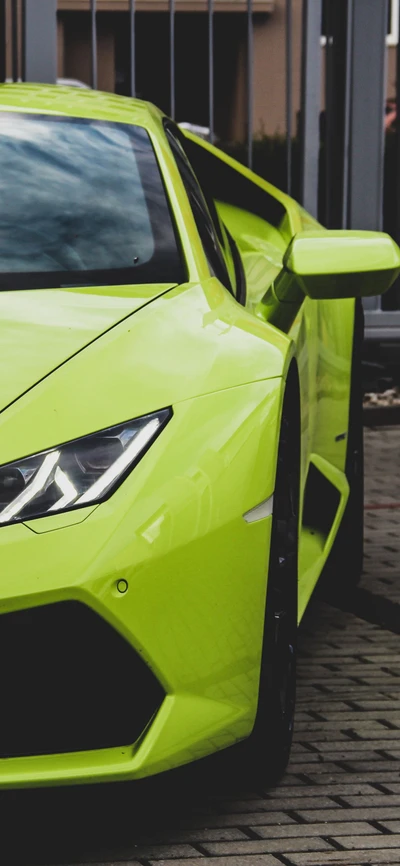 Vibrant green Lamborghini parked, showcasing its sleek design and distinctive headlights.