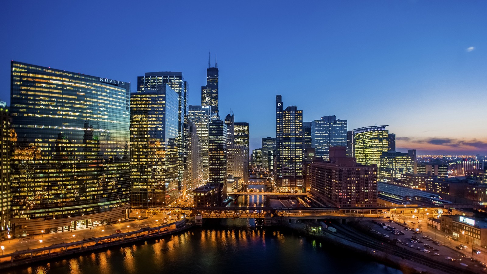 A view of a city skyline at night with a bridge and buildings (chicago, skyscraper, city, cityscape, urban area)