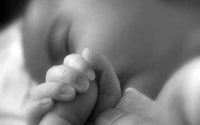 Monochrome Tenderness: A Child's Finger Holding an Infant's Hand