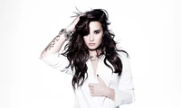 Demi Lovato in einer auffälligen Pose vor einem weißen Hintergrund, die ihren charakteristischen Stil und ihre Ausstrahlung zeigt.