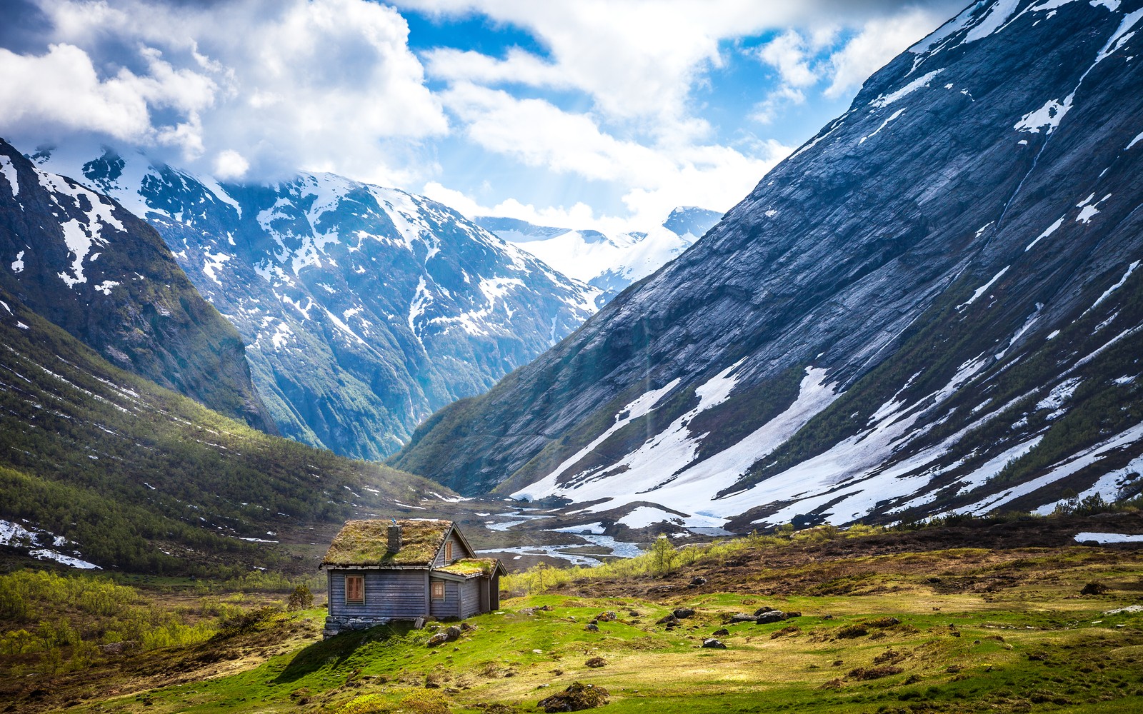 Eine aussicht auf eine kleine hütte inmitten eines bergtals (gletschermassive, norwegen, landschaft, hochebene, holzhaus)