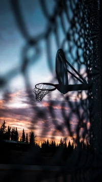 Silhouette d'un panier de basketball au coucher du soleil