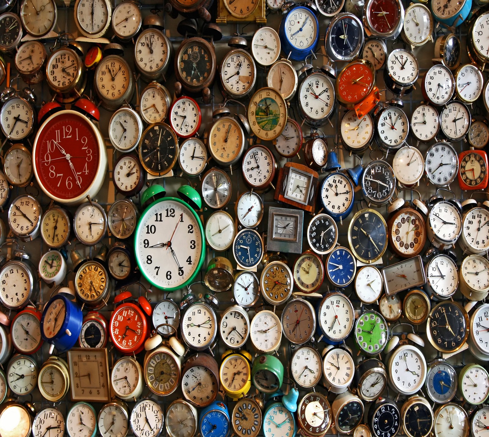 A close up of a wall of clocks with different time zones (abej, alarm clocks, beograd)