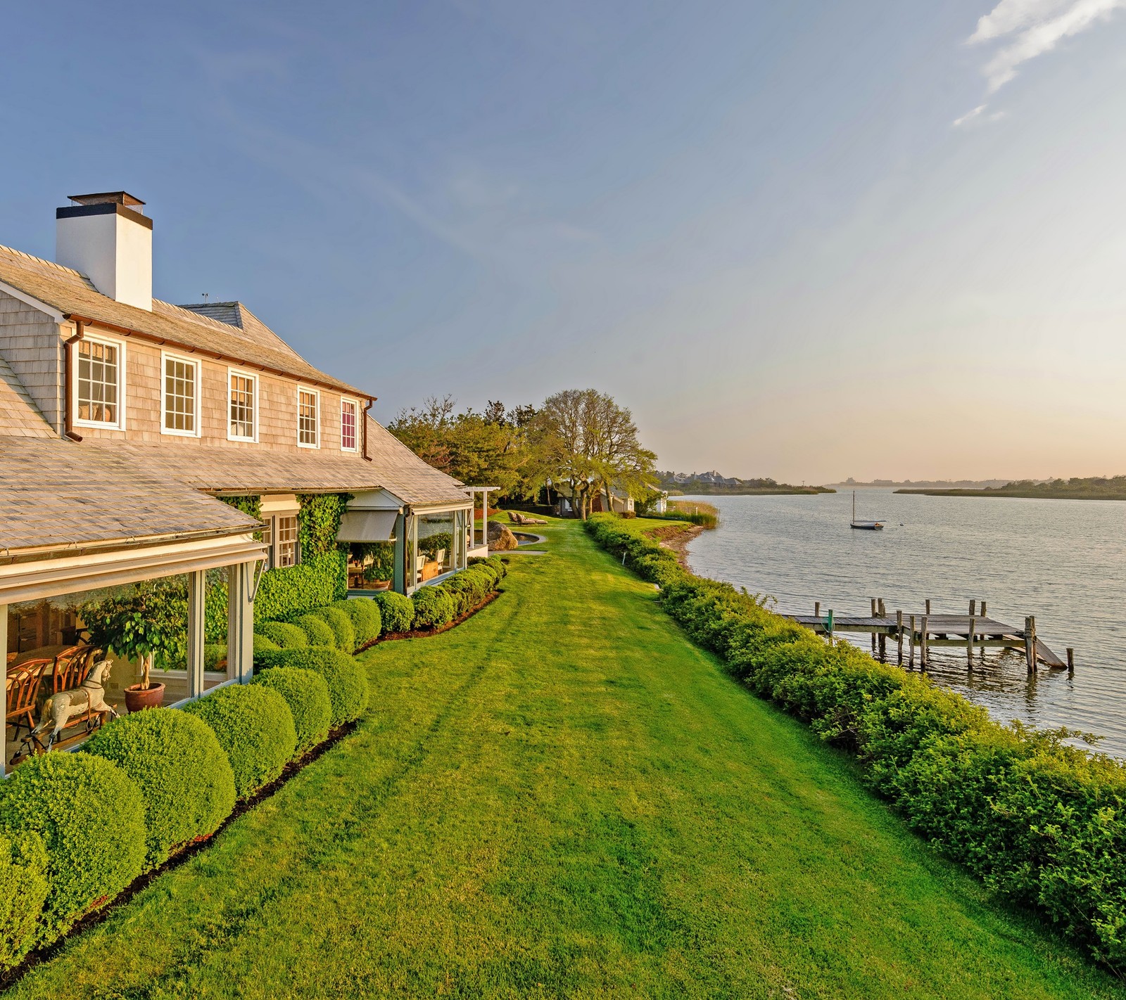 Uma vista de uma casa com um barco na água (lar, casa, luxo, ny, caminho)