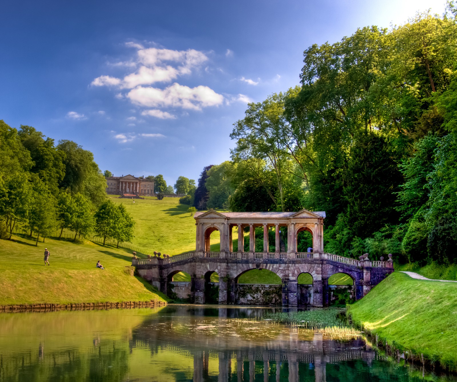 Мост арафед над прудом в парке с замком на заднем плане (bath, prior park)