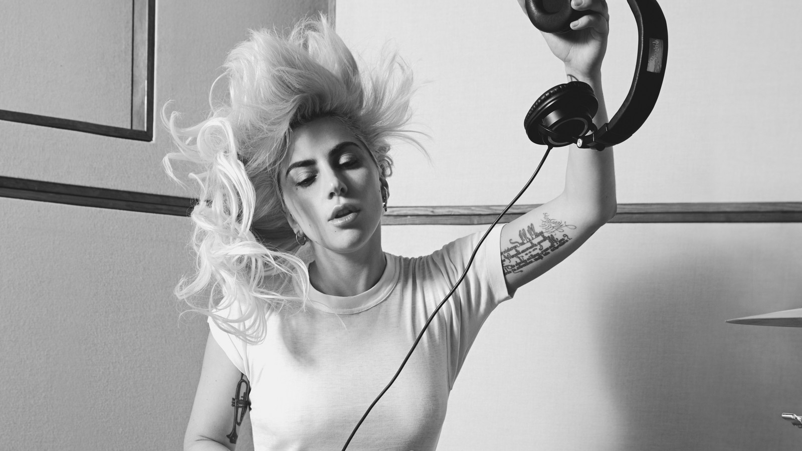 Une femme africaine avec des écouteurs et un tatouage sur le bras (lady gaga, album, épaule, monochrome, muscle)