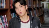 Soobin from Tomorrow X Together in a library setting, exuding a contemplative vibe.