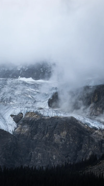 Geleira majestosa entre um terreno montanhoso acidentado e nuvens