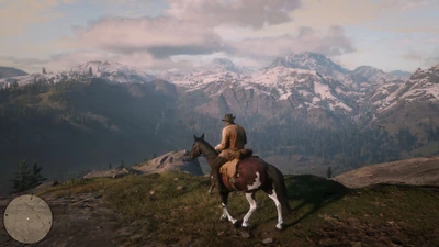 Um cowboy a cavalo observa uma paisagem montanhosa de tirar o fôlego em Red Dead Redemption 2.