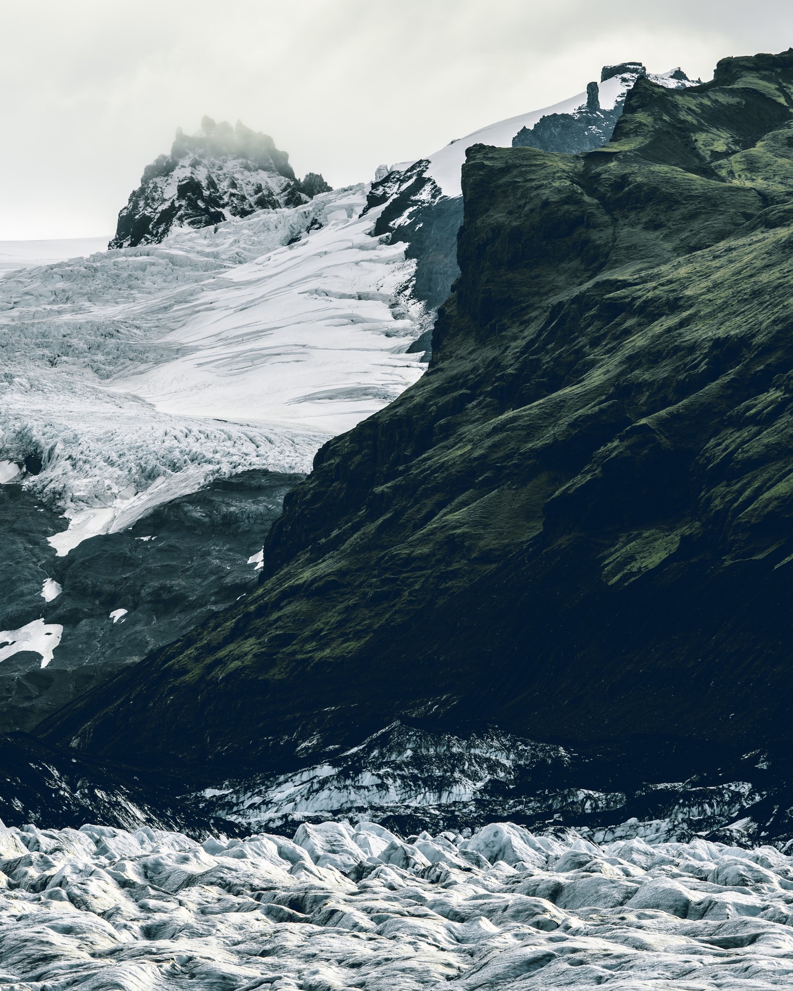 Un homme se tient sur une planche de surf dans l'eau (promontoire, formation terrestre, glacier, océan, mer)