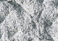 Surface de granit blanc texturé présentant des motifs complexes et des inclusions minérales, idéale pour l'étude géologique ou les applications architecturales.