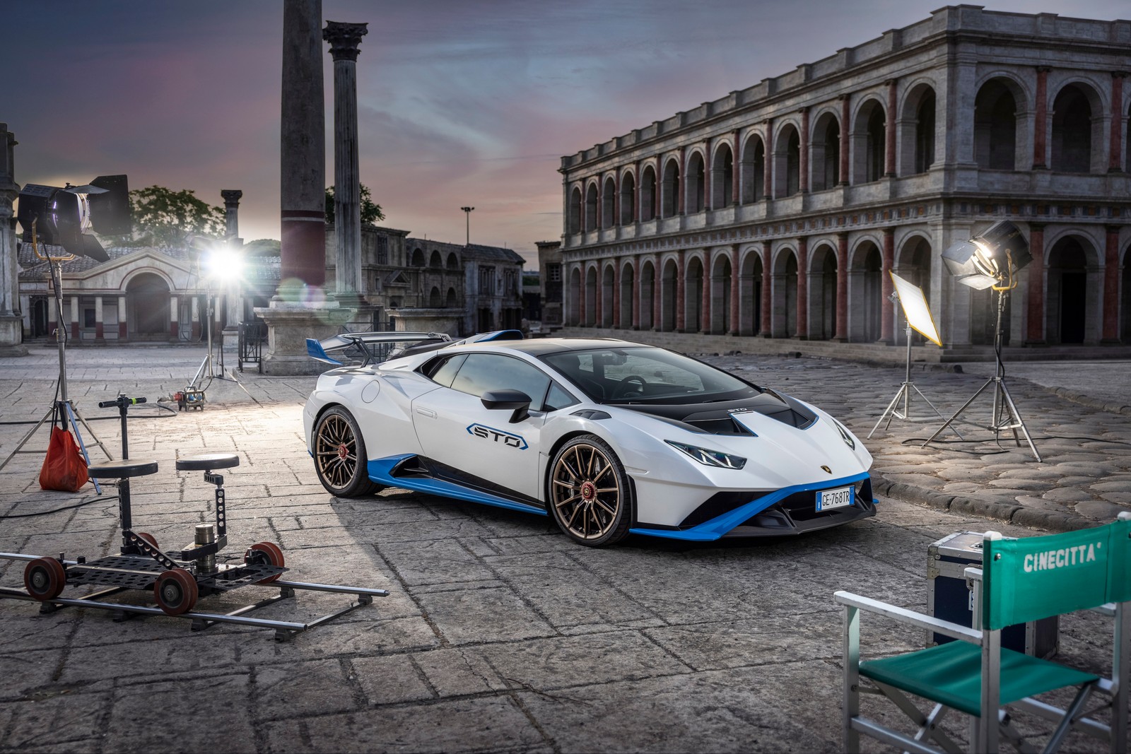 Un lamborghini blanco estacionado frente a un edificio con una cámara instalada (lamborghini huracán sto, cinematográfico, coches deportivos, 2021, 5k)