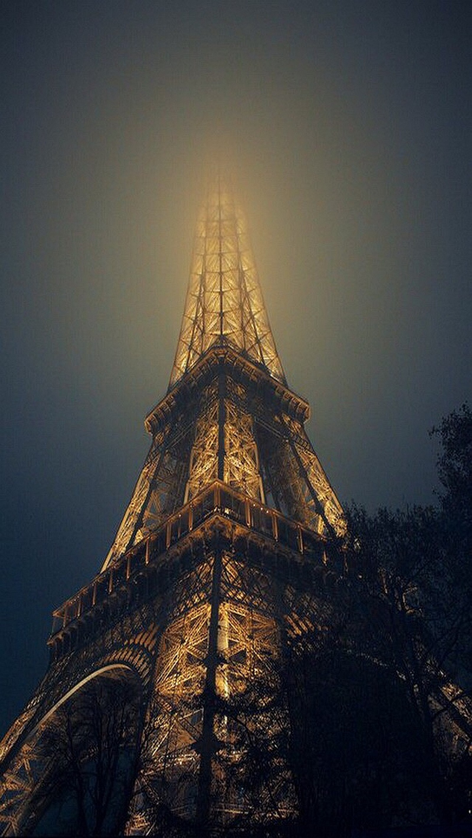 Vista arafed da torre eiffel à noite com um céu nebuloso (torre eiffel, torre)