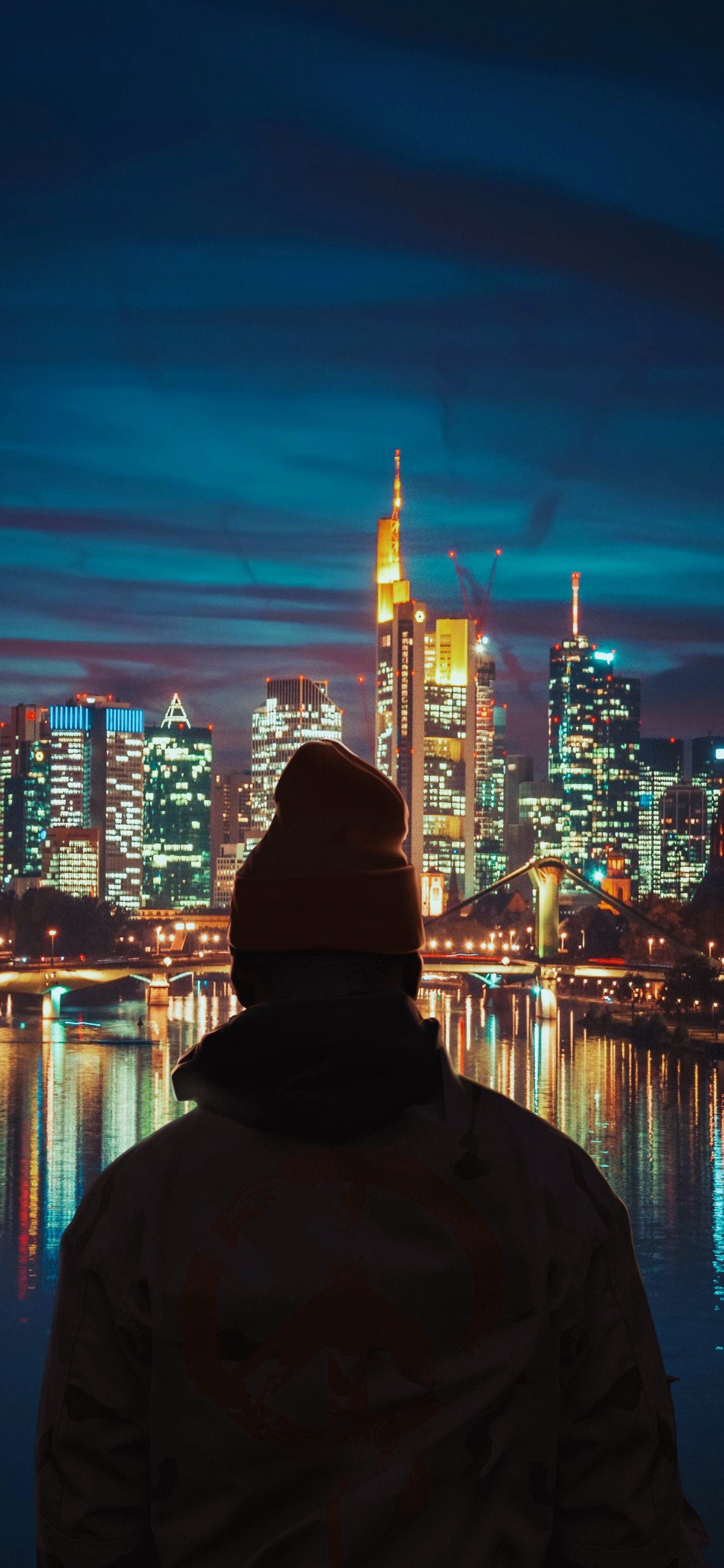 Vue arabe d'un homme regardant une ville la nuit (paysage urbain, eau, bâtiment, nuage, gratte ciel)